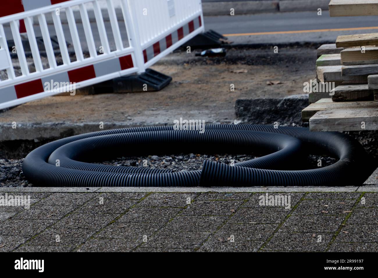 Black corrugated plastic tube laying on a construction site Stock Photo
