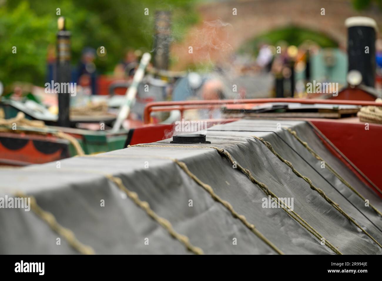 Smoke rises from the chimney of a boat taking part in the annual Historic Narrowboat Rally in Braunston, Northamptonshire Stock Photo