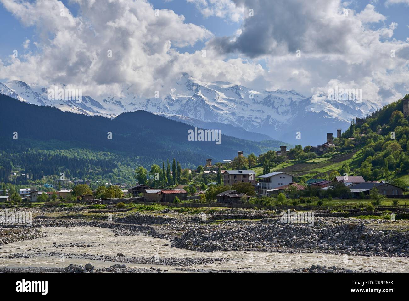 Mestia, Stadt mit Wehrtürmen, vorne der Fluss Mestiachala, schneebedeckte Berge, Hoher Kaukasus, Swanetien, Georgien Stock Photo