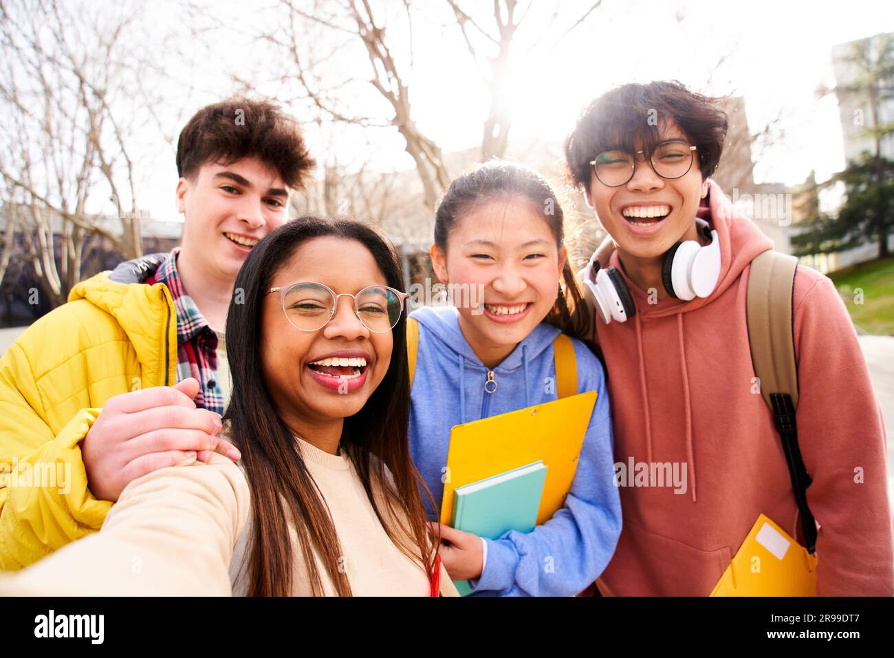 Group of multi-ethnic high school students taking a selfie. They are ...