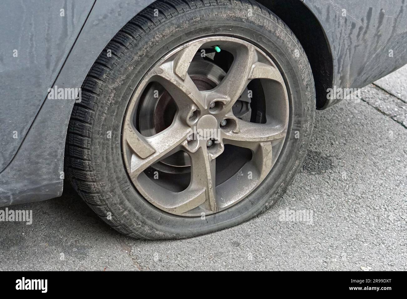 Flat tire deflated pneumatic car tyre wheel problem at street Stock