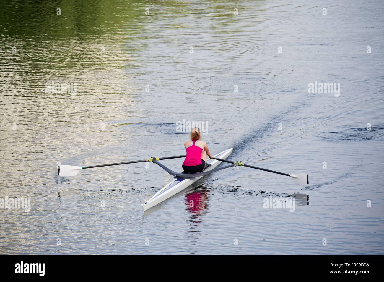 Women training on canoe to practise rowing during early morning on river Stock Photo