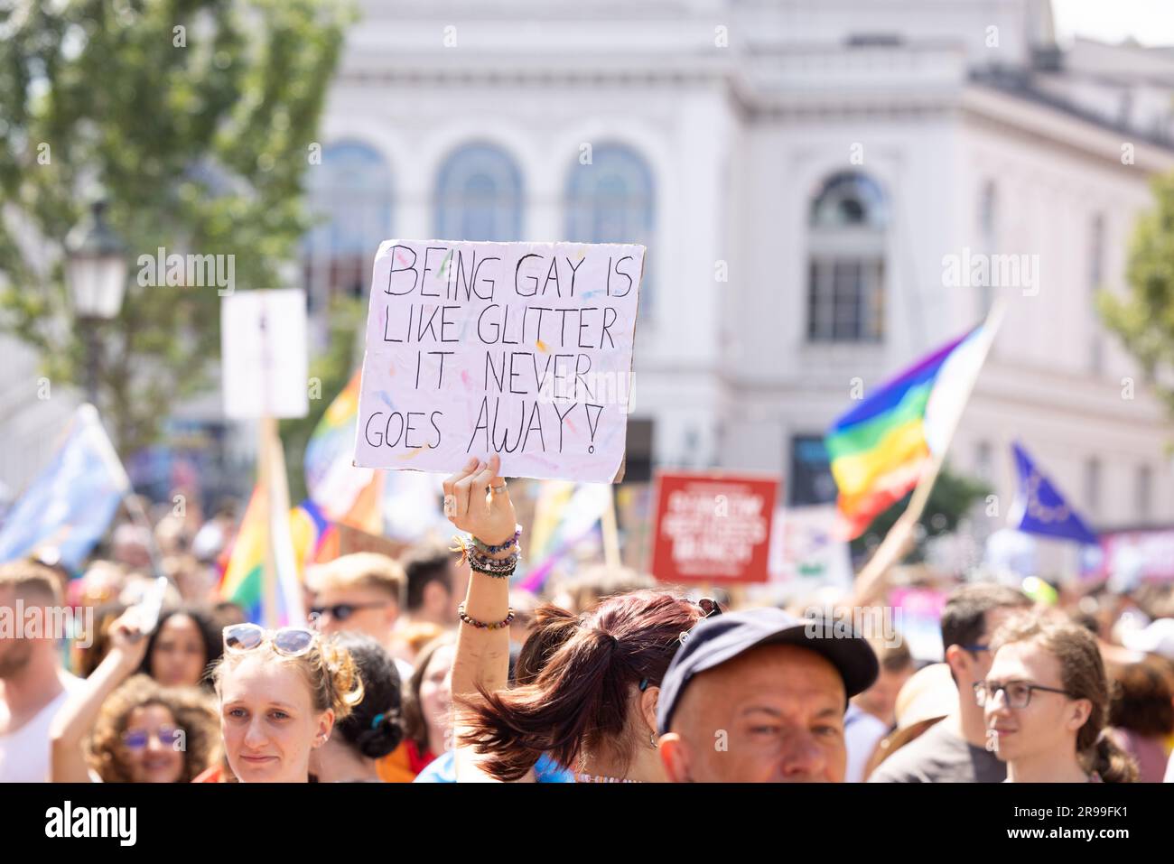 Munich, GERMANY - June 24, 2023: People at the Parade at Christopher Street  Day CSD in Munich. Poster with the text 'Being gay is like glitter - it n Stock Photo