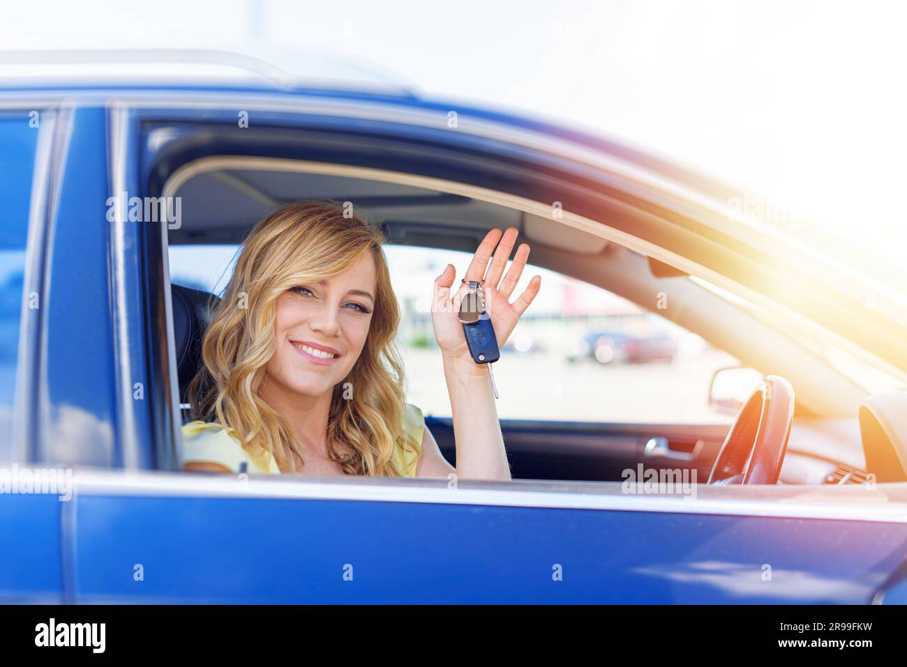 A beautiful blonde woman holds a car key in her hand Stock Photo - Alamy