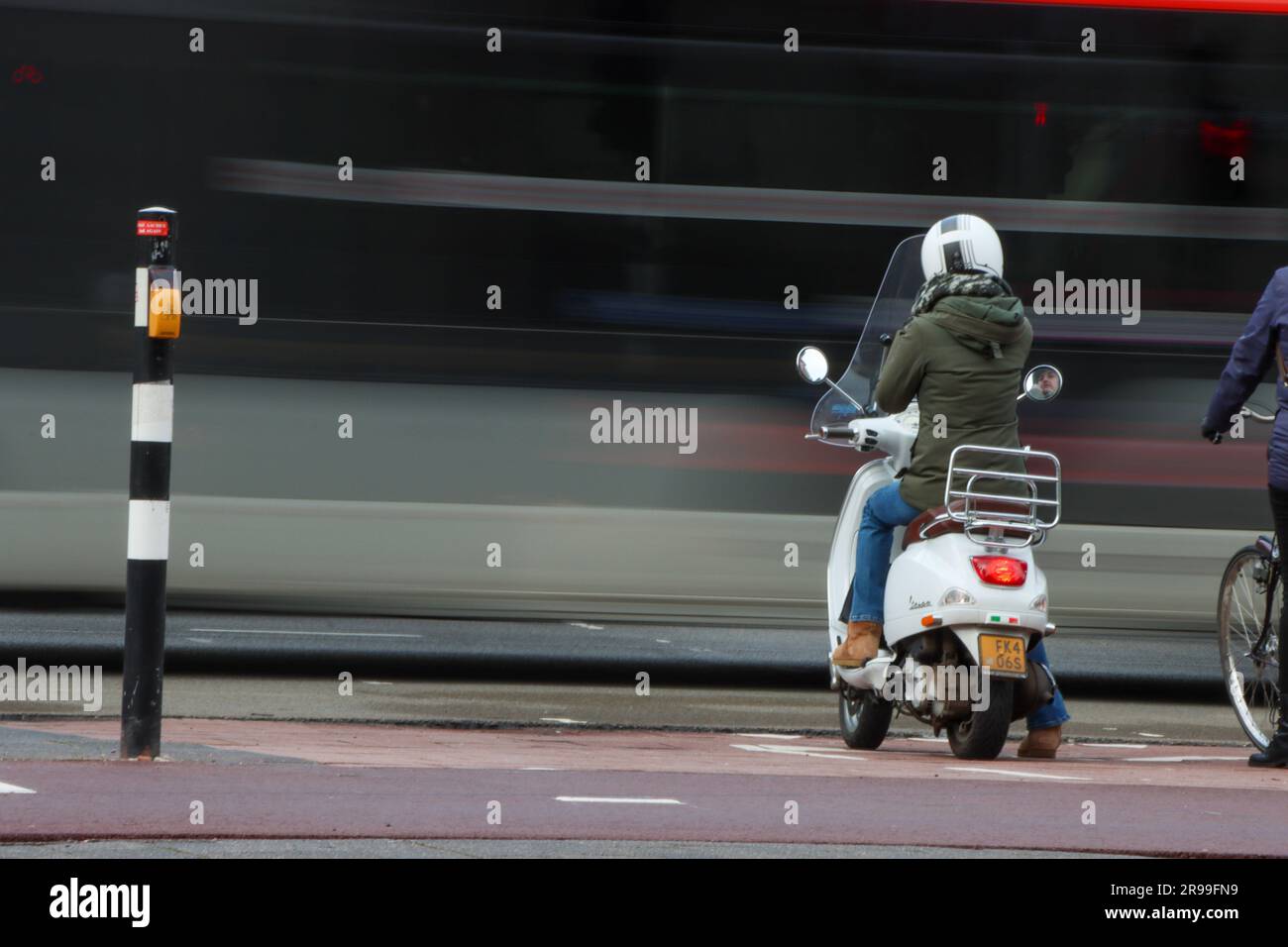 A street scene in Eindhoven featuring a bus and a woman on a scooter Stock Photo Alamy