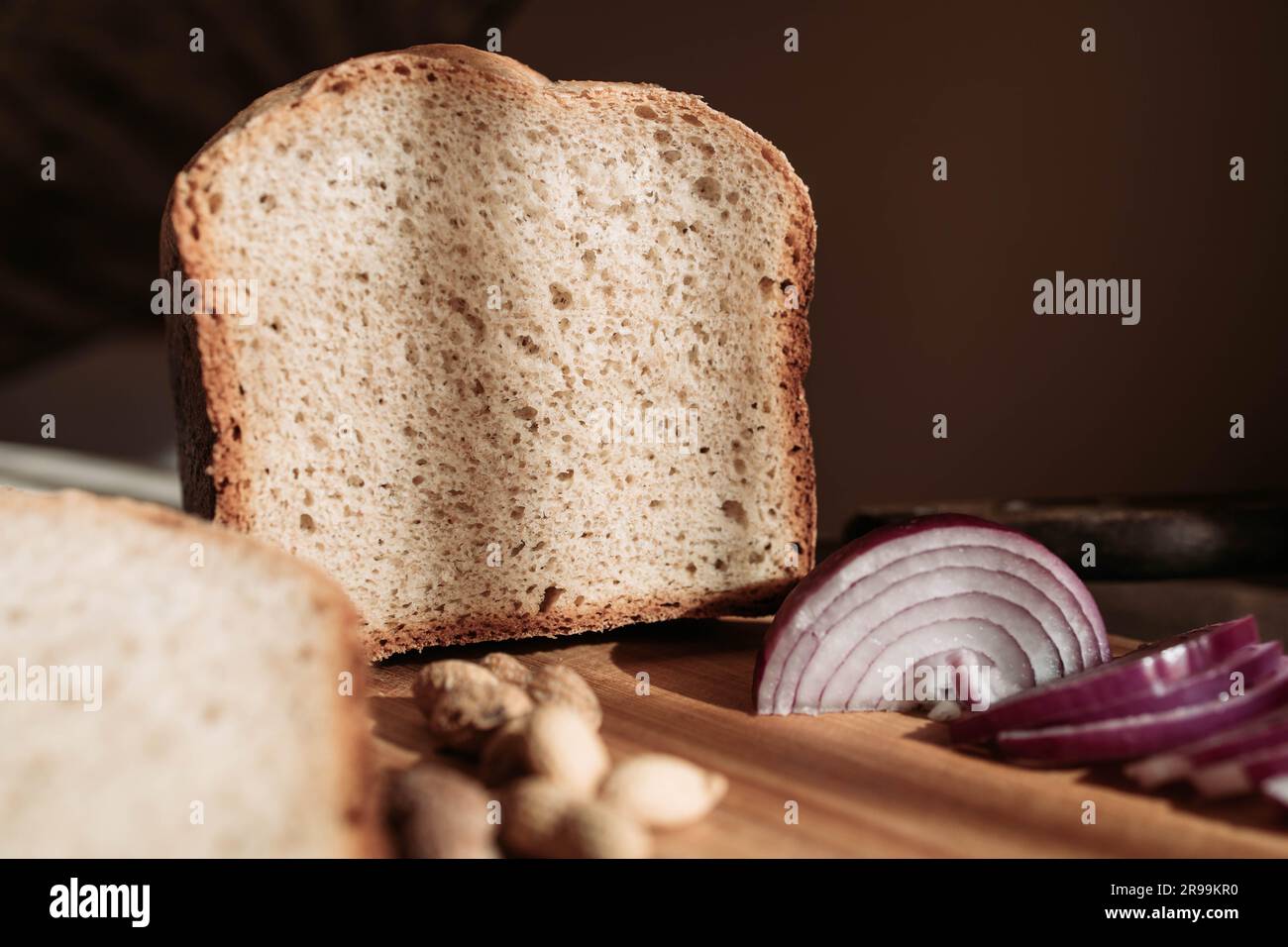 Homemade wheat flour loaf of bread with peanuts and red onion on the