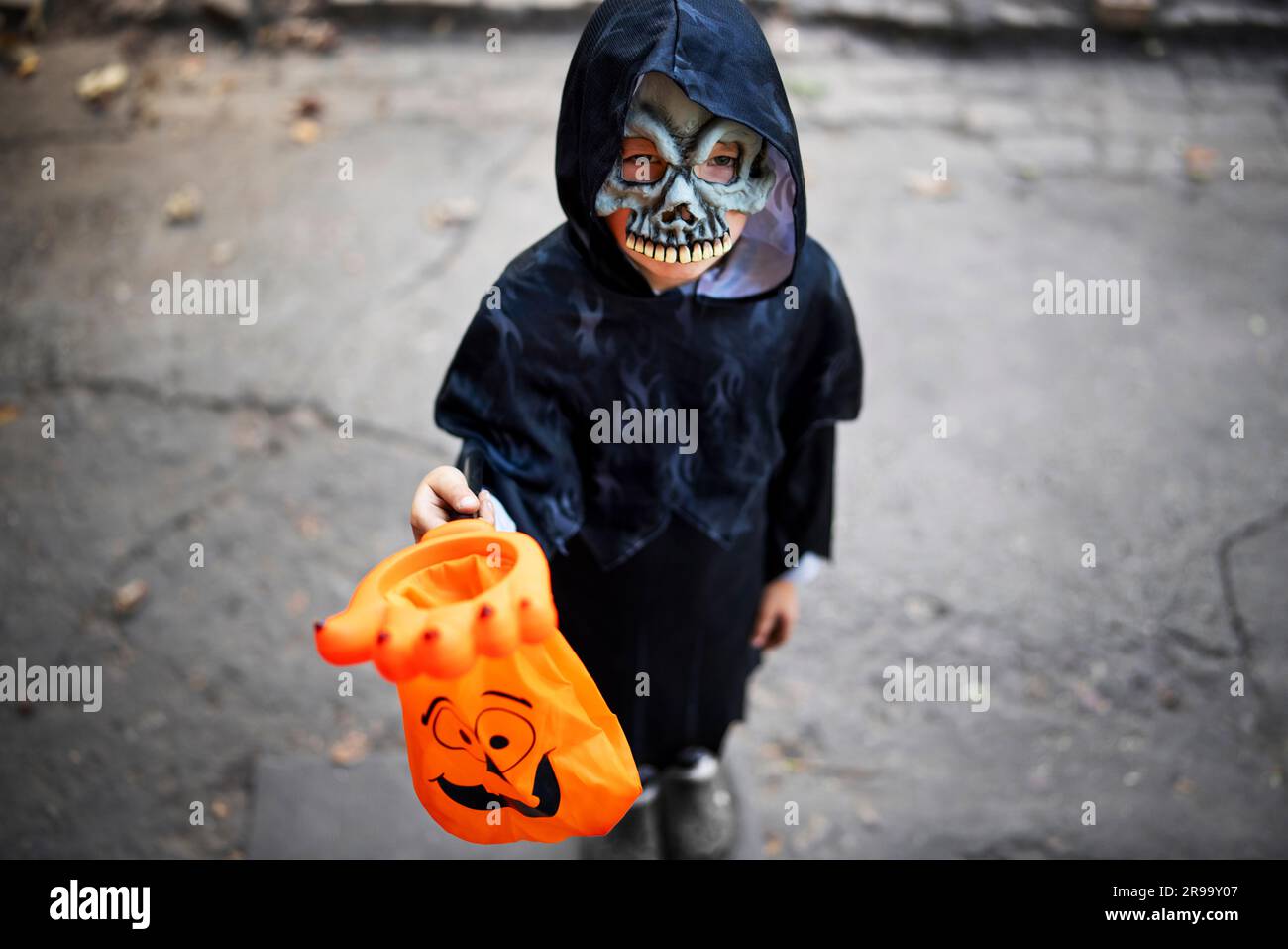 Little boy in halloween costume and mask holding special candy bag in his hand. Stock Photo