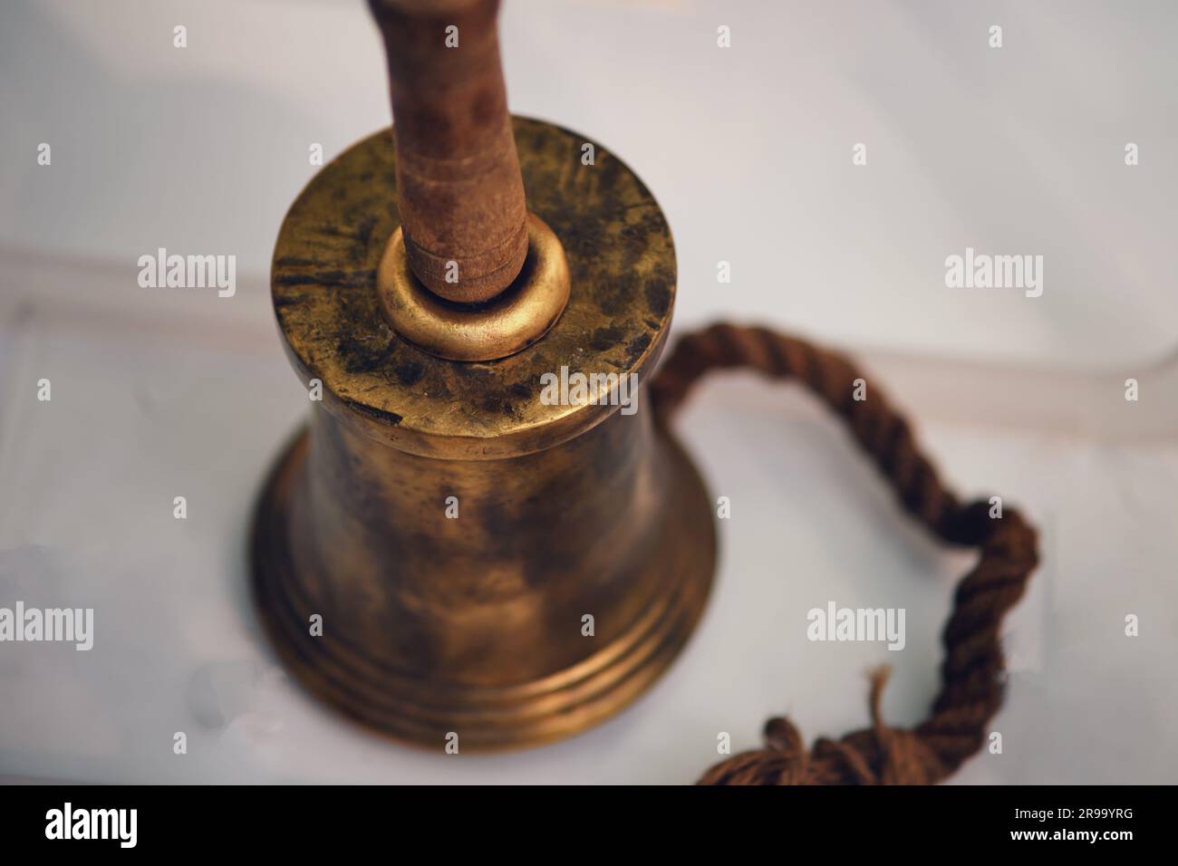 Old ship hand bell made of yellow metal, close-up. Old objects of the 18th century era, reenactment of events Stock Photo