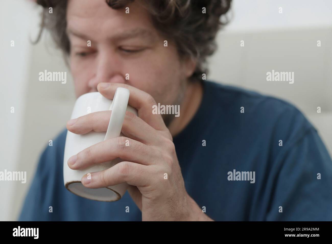portrait caucasian man drinking from a large cup Stock Photo
