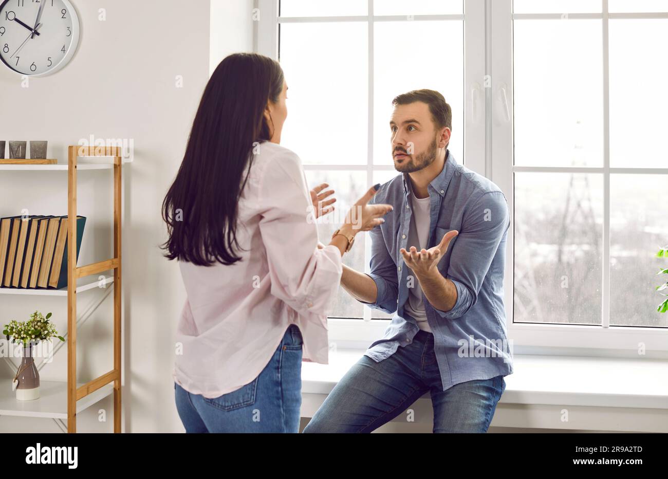 Annoyed young family couple arguing emotionally, blaming each other Stock Photo