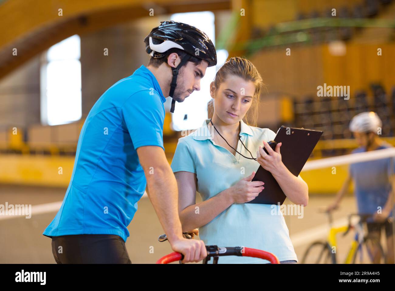 male cyclist with coach training in the velodrome Stock Photo