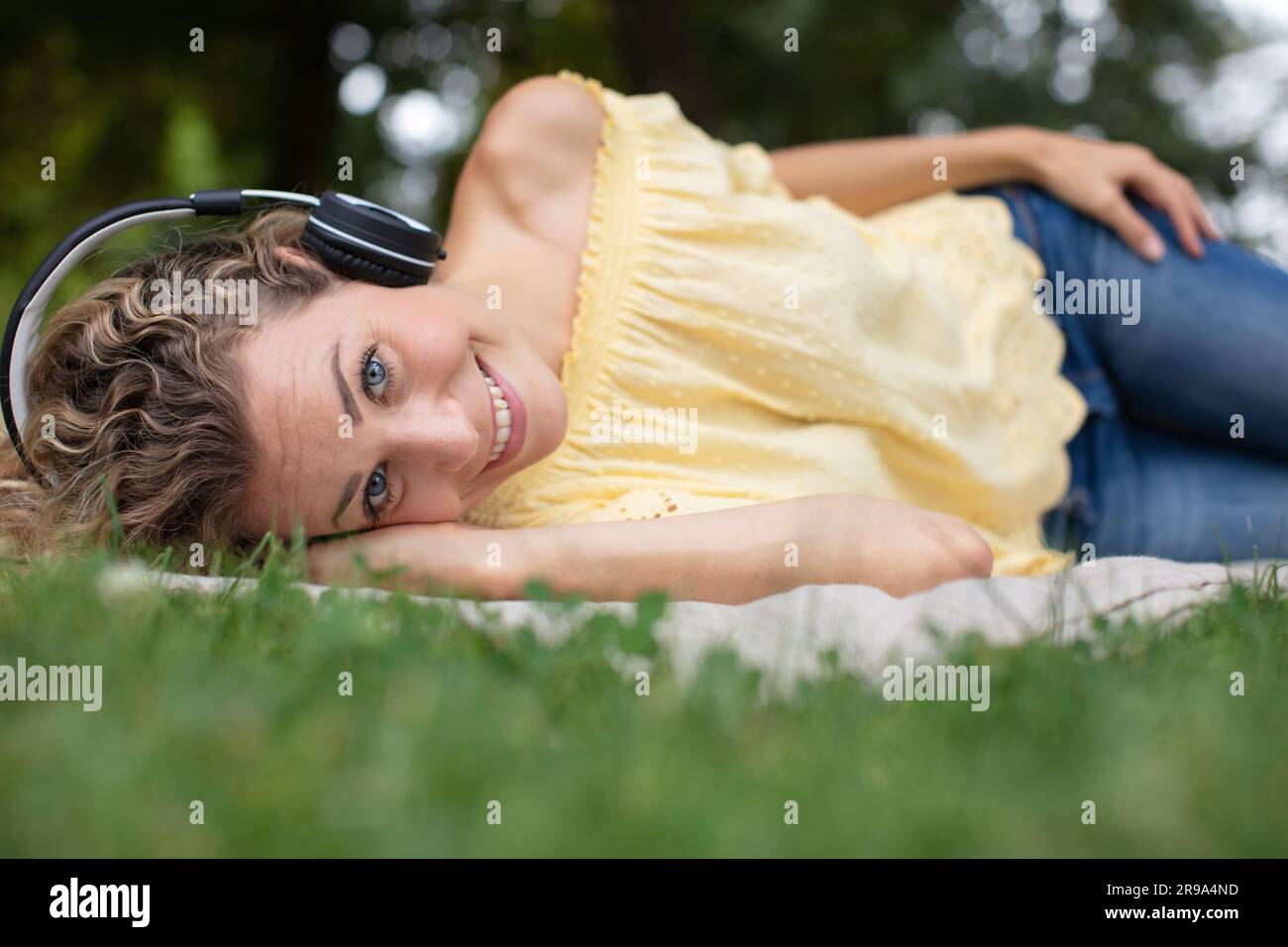 woman lying on grass listening to music Stock Photo - Alamy