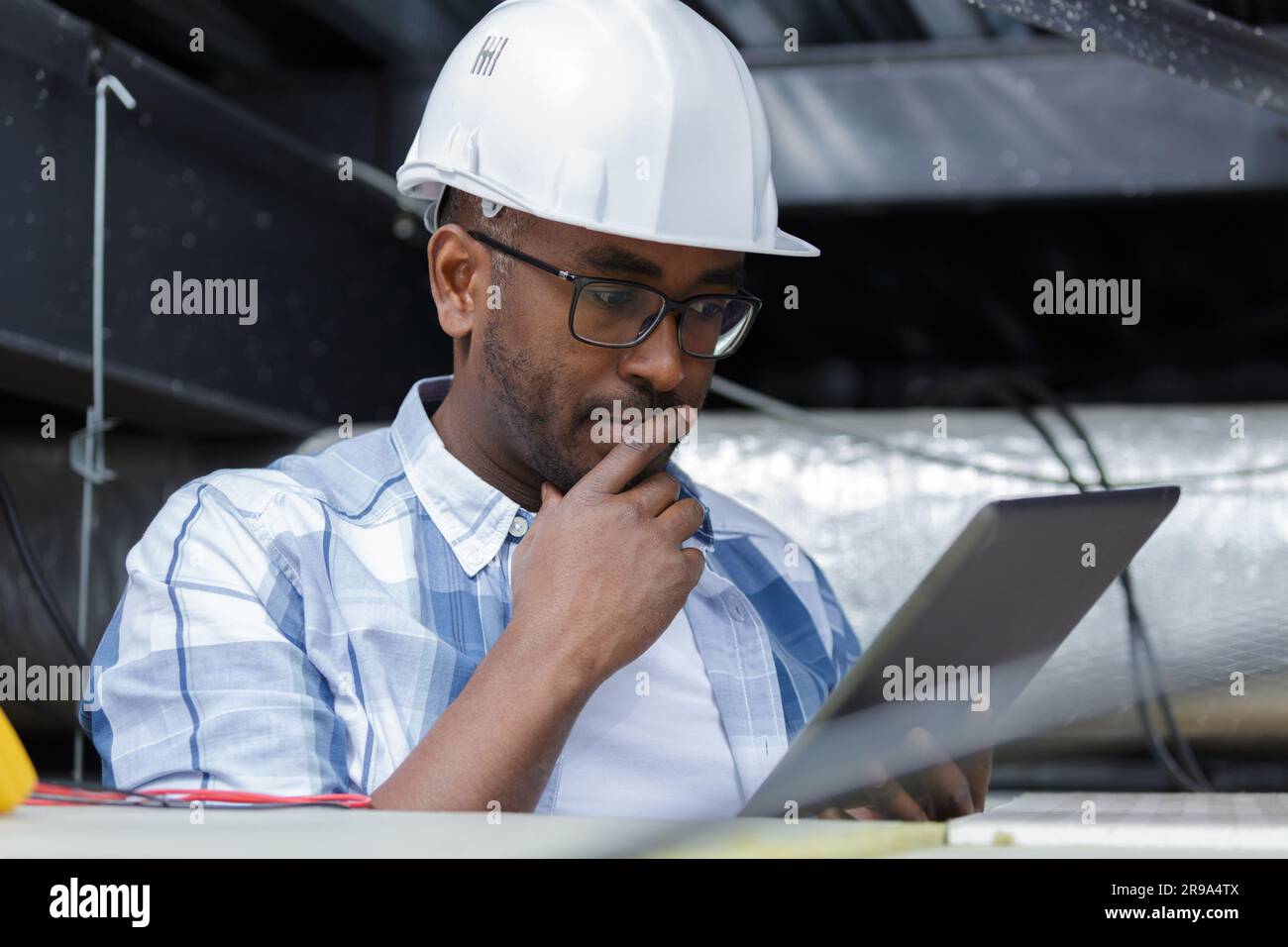 electrician doing test with tablet pc in ceiling Stock Photo