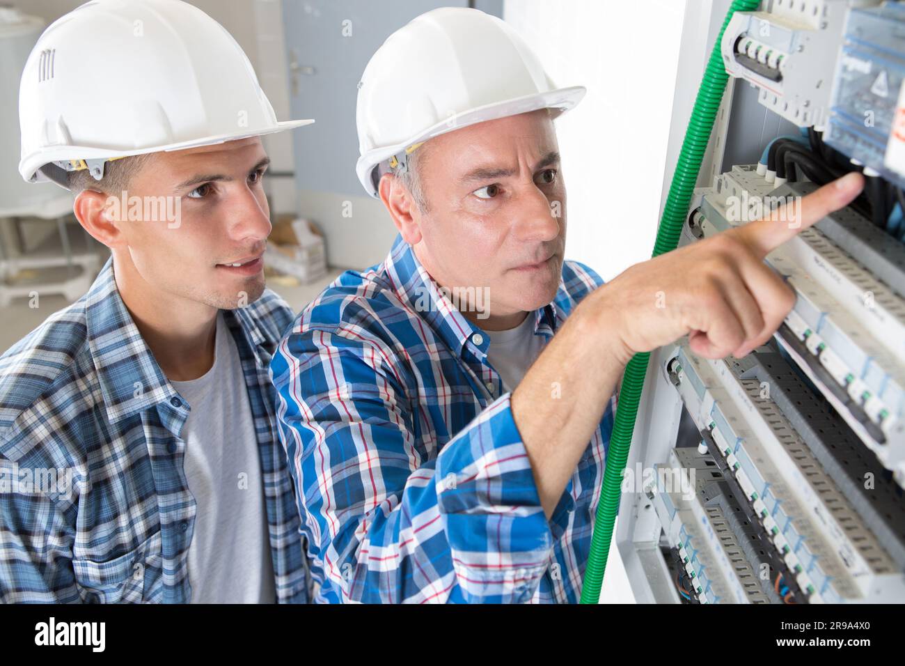 tradesmen installing a distribution board Stock Photo Alamy