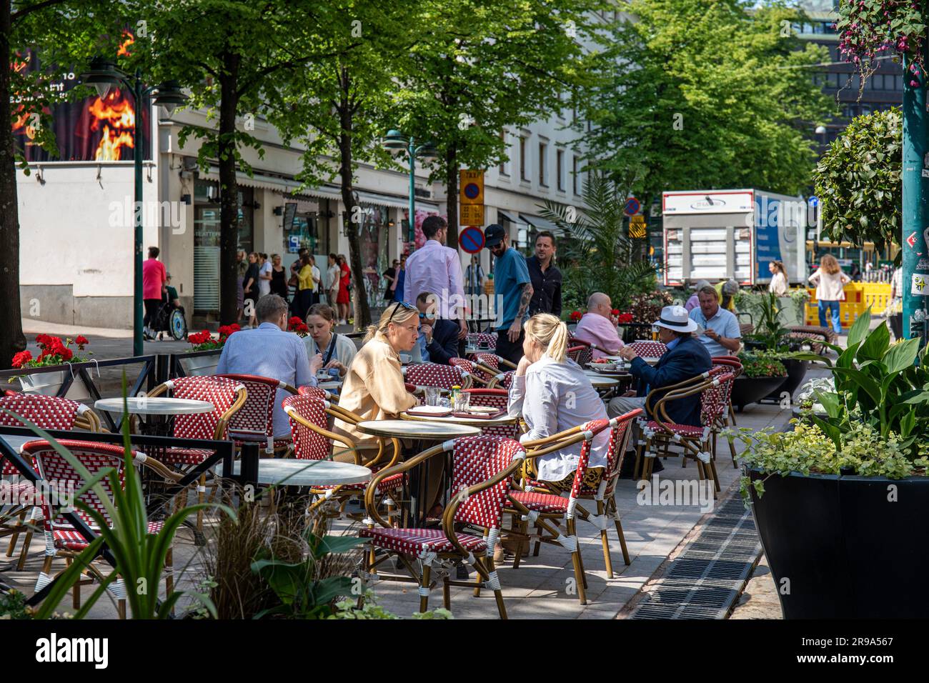 People sitting at café outdoor seating in Pohjoisesplanadi, Helsinki, Finland Stock Photo