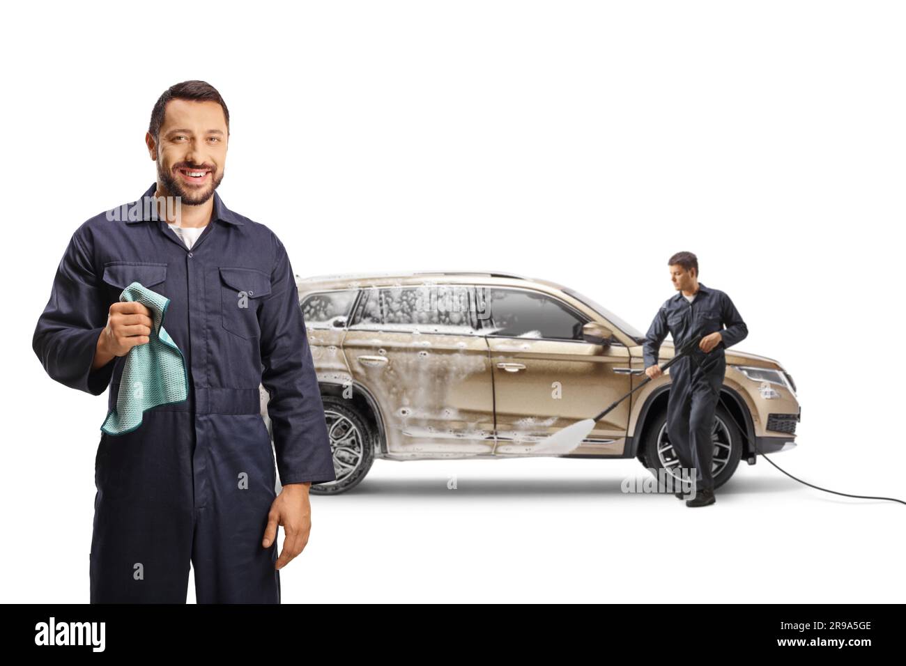 Workers washing a SUV at a car wash and holding a cloth isolated on
