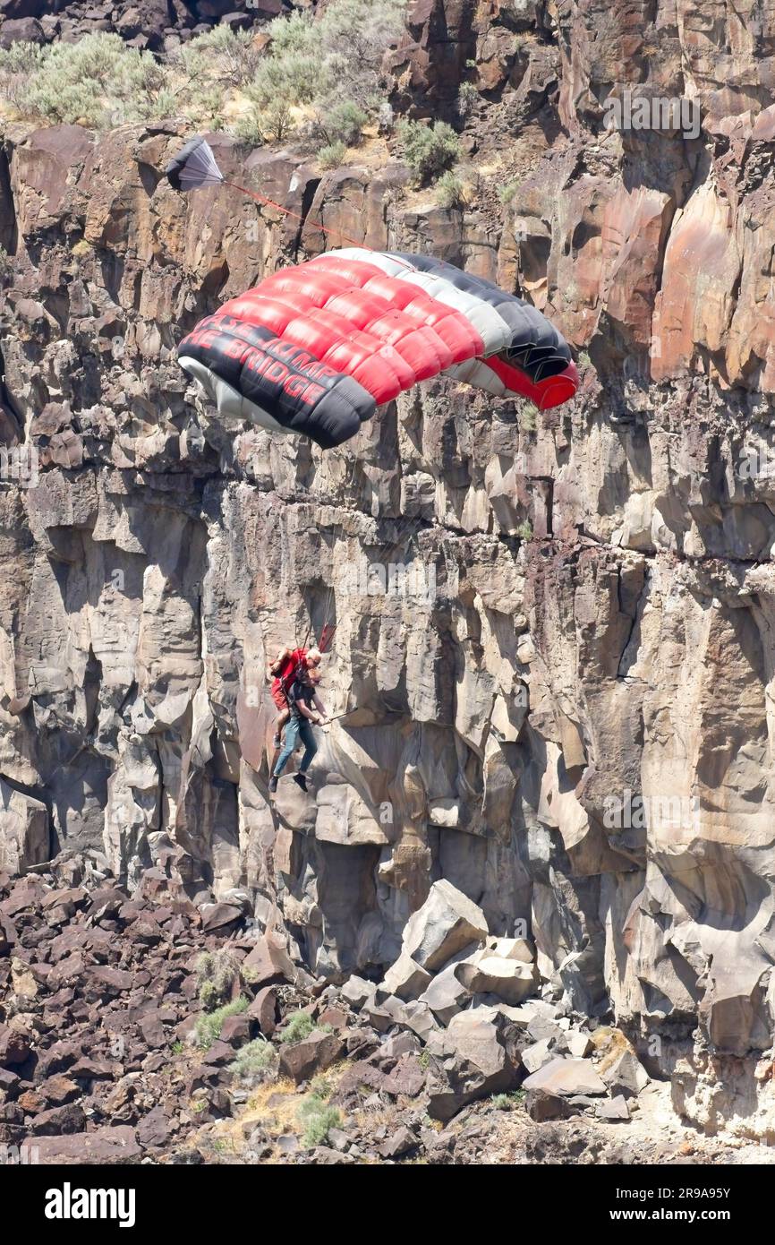 Tandem base jumpers soaring down the canyon after jumping off the bridge at Twin Falls, Idaho. Stock Photo