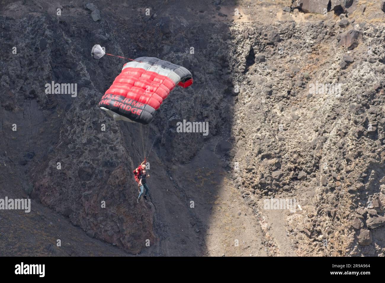 Tandem base jumpers soaring down the canyon after jumping off the bridge at Twin Falls, Idaho. Stock Photo