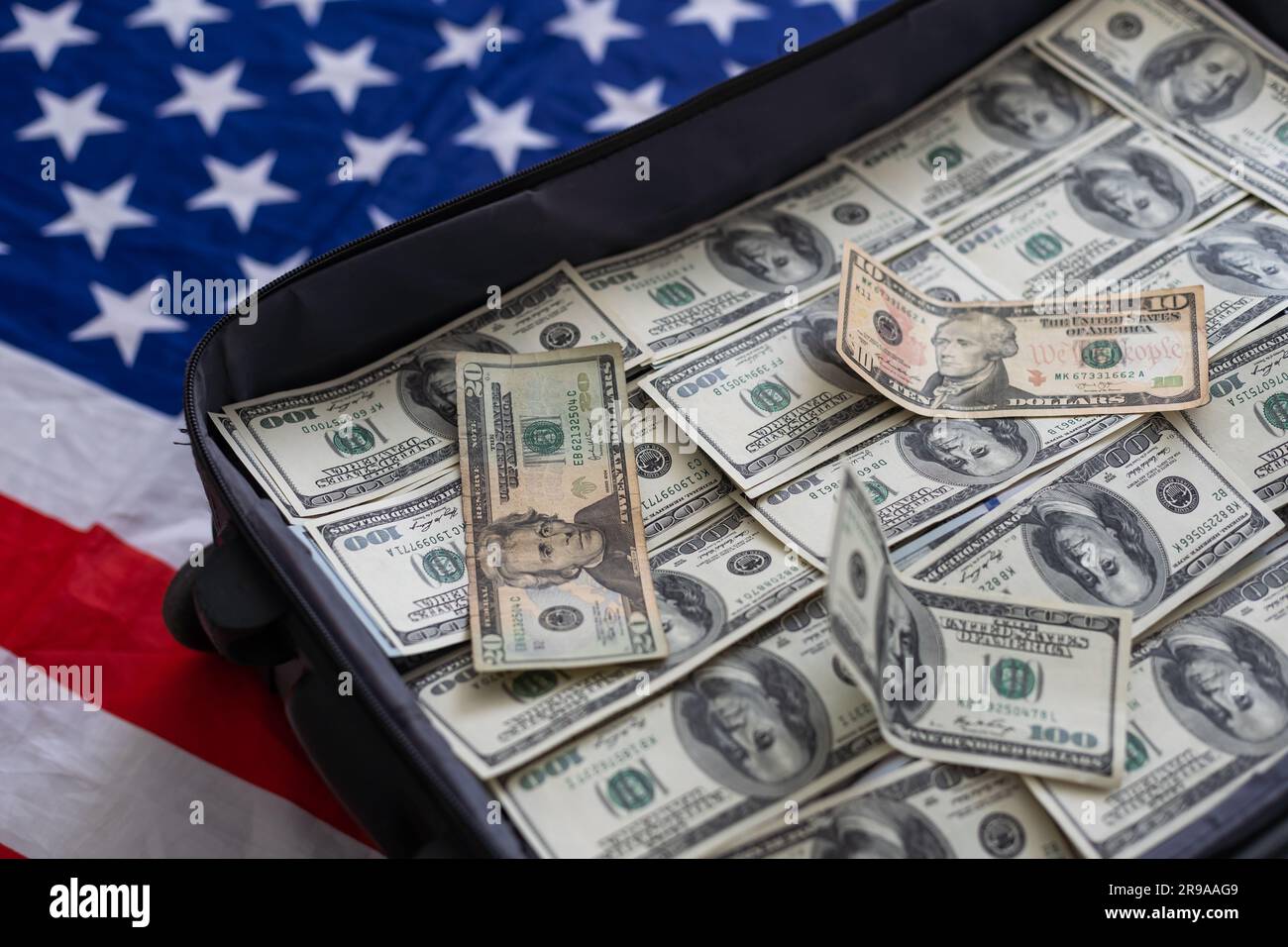 Suitcase with pile of dollars. Opened silver case with money. Better to