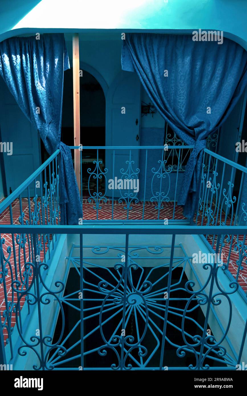Center of multi floored metal railings at Riad Nerja in Chefchaouen,  with the traditional blue theme repeated up three floors draped with blue silk Stock Photo
