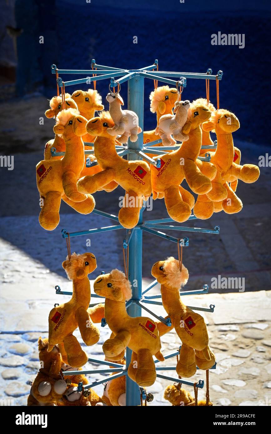 A display fixture of hanging stuffed animal camels monogramed 'Morocco' at a souvenir shop on the streets in Chefchaouen, Morocco Stock Photo
