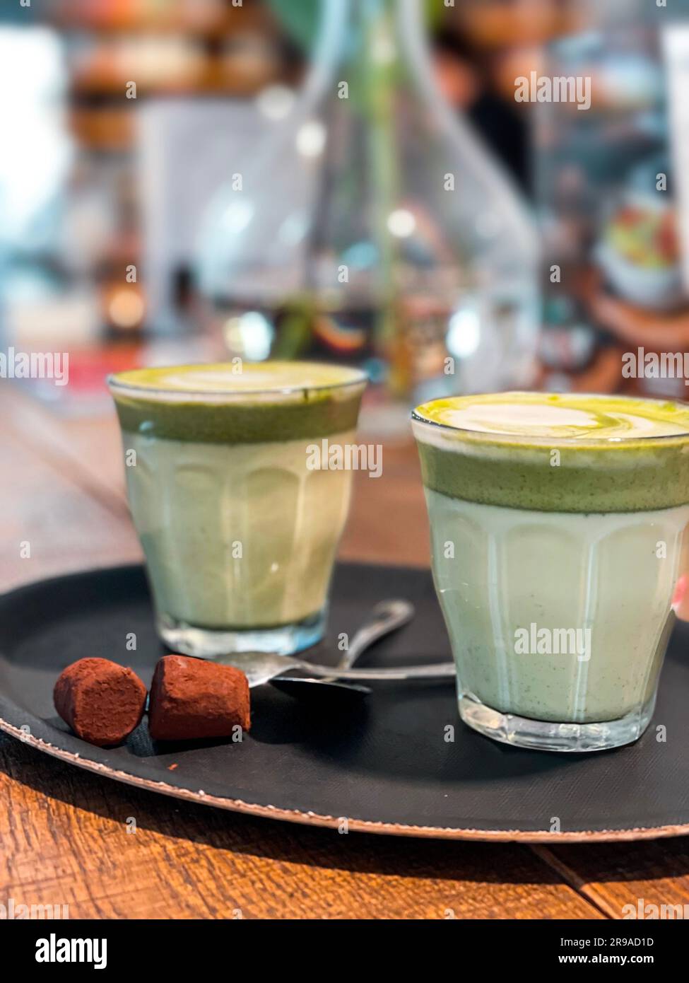 Two glass cups of matcha latte drinks on a wooden table Stock Photo
