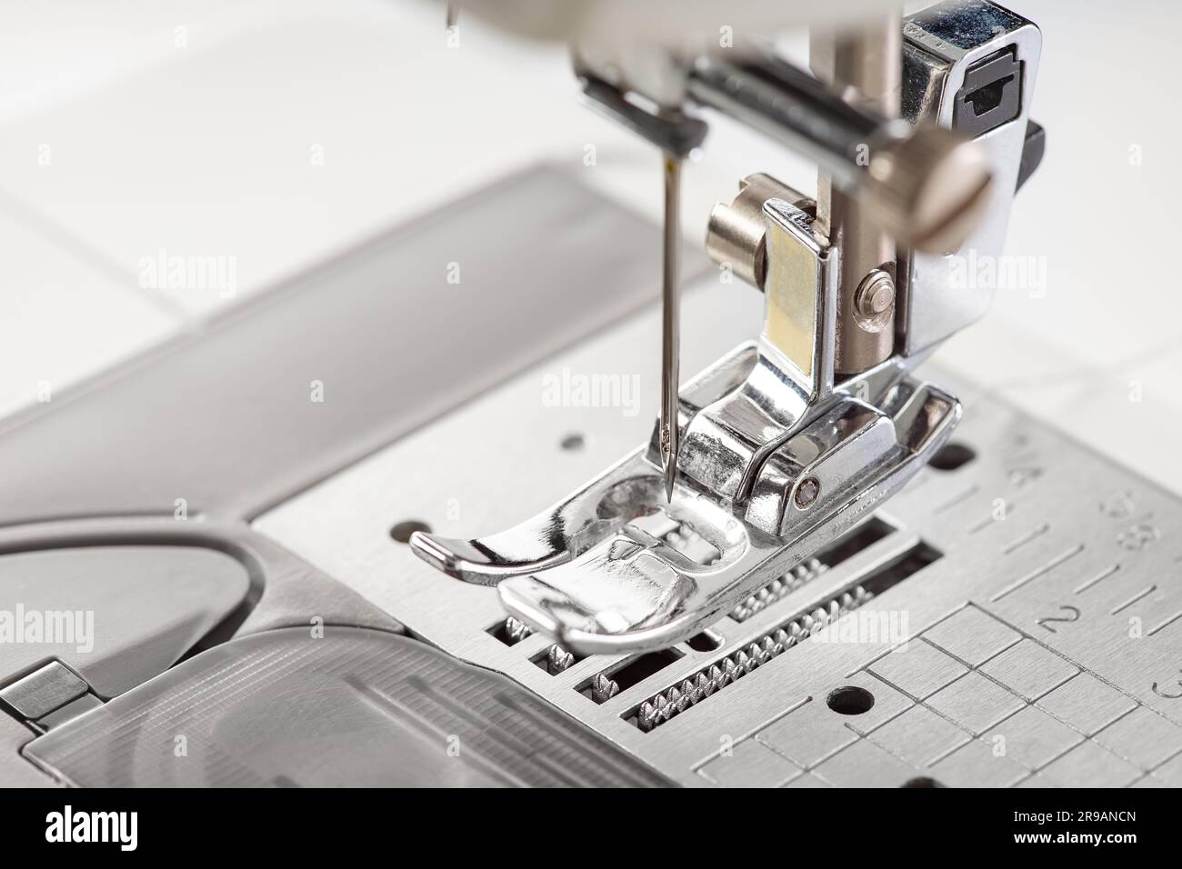 Modern white sewing machine presser foot closeup, macro. Sewing equipment, work tool for atelier