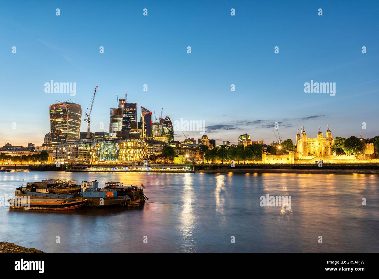 The Tower of London and the City skyscrapers after sunset Stock Photo