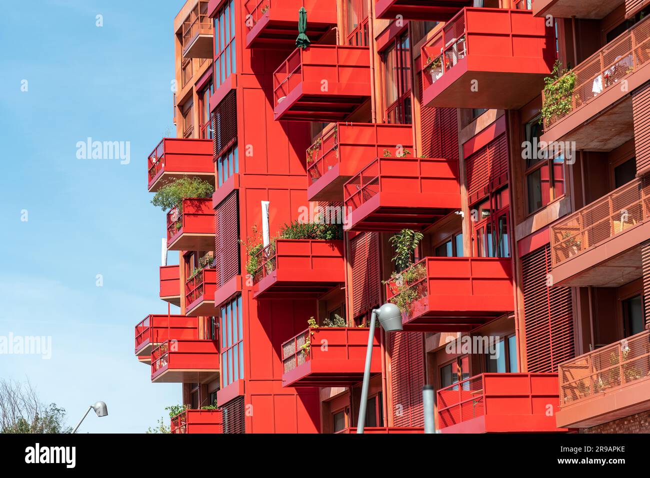 Facade of a modern red apartment building with many balconies in Berlin