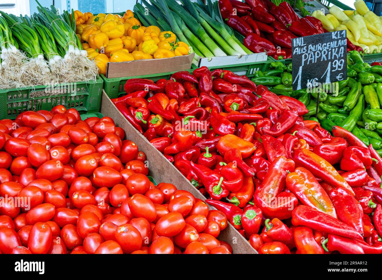 Different types of peppers and other vegetables for sale at a market ...