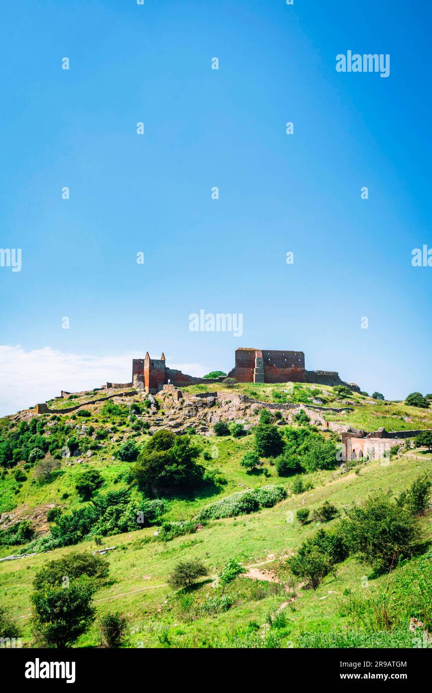 Castle ruin in a green landscape under a blue sky in the summer Stock Photo