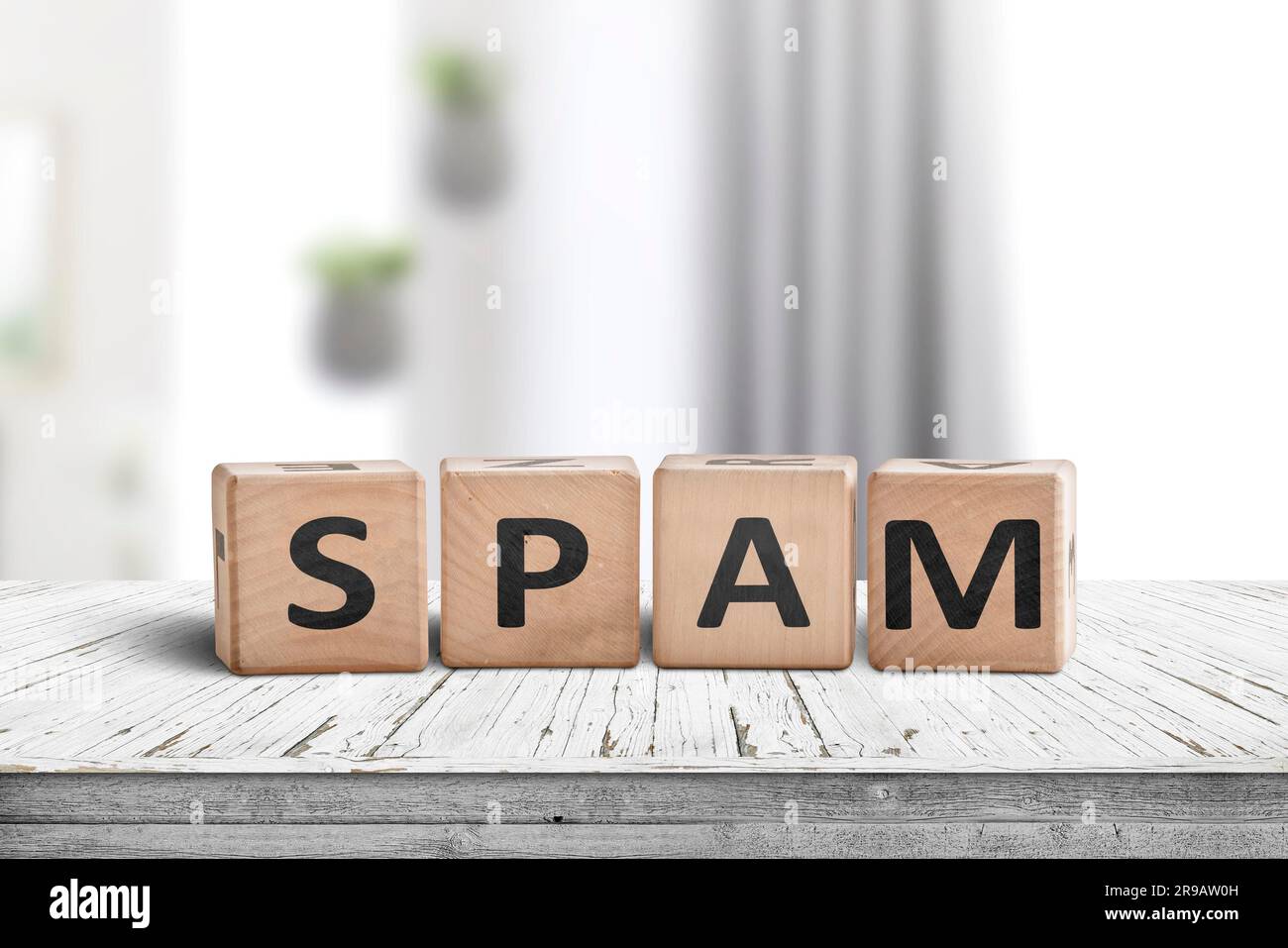 Spam sign on a white desk with wooden blocks in a bright room Stock Photo