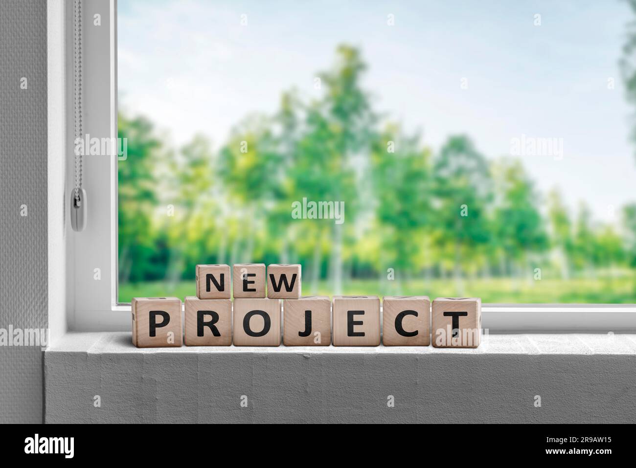 New project sign in a window sill with green trees in the garden Stock Photo