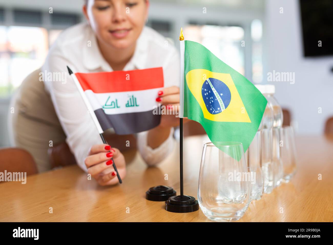 Little flag of Brazil on table and flag of Iraq put next to it by young ...
