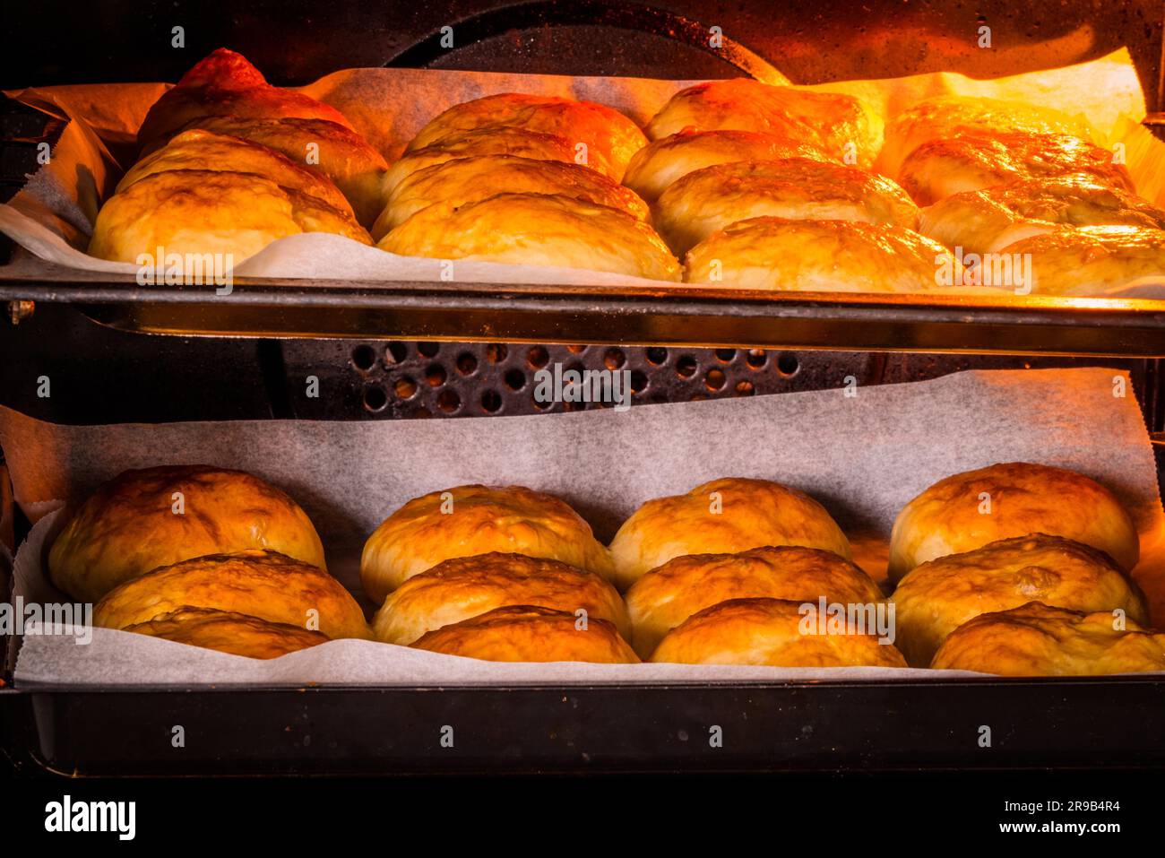 Golden brown buns in a hot oven at a bakery Stock Photo - Alamy