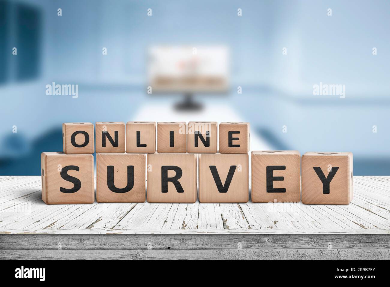 Online survey sign on a table in a blue room with a monitor Stock Photo