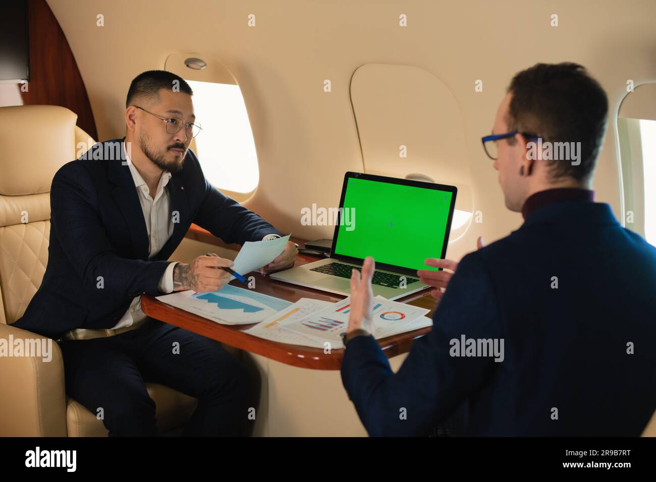 Two Businessman CEO couple in eyeglasses sitting inside a private jet