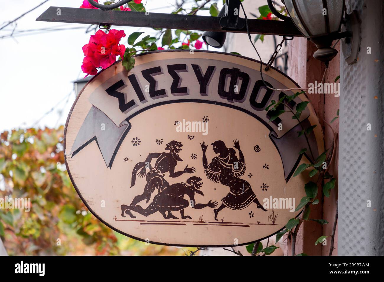 Athens, Greece - 25 Nov 2021: Metal signage of a caffe in Plaka district of Athens. The Greek writing translates as Sissyphos. Stock Photo