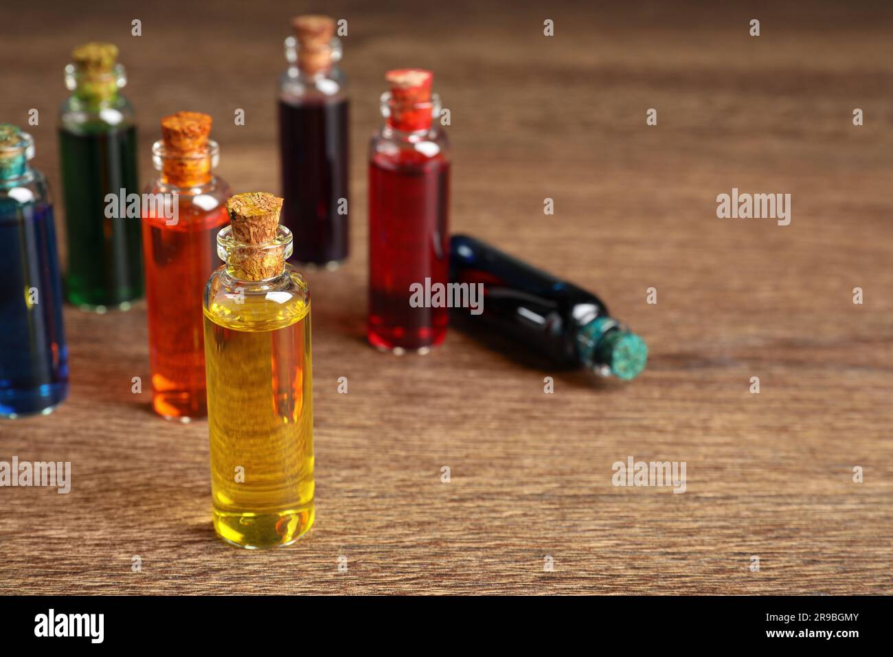 Bottles with different food coloring on wooden background, space for text Stock Photo