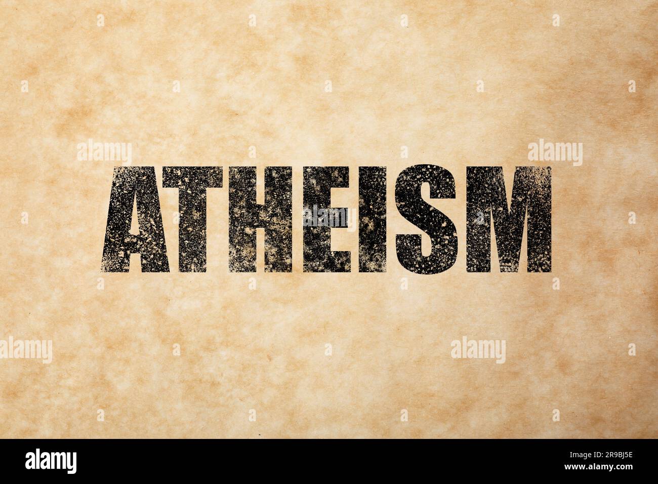 Black word Atheism on beige textured background. Philosophical or religious position Stock Photo