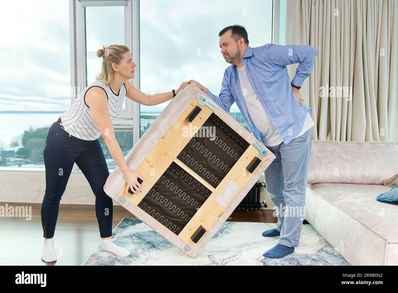 Family rearranging furniture couple moving furniture in new apartment