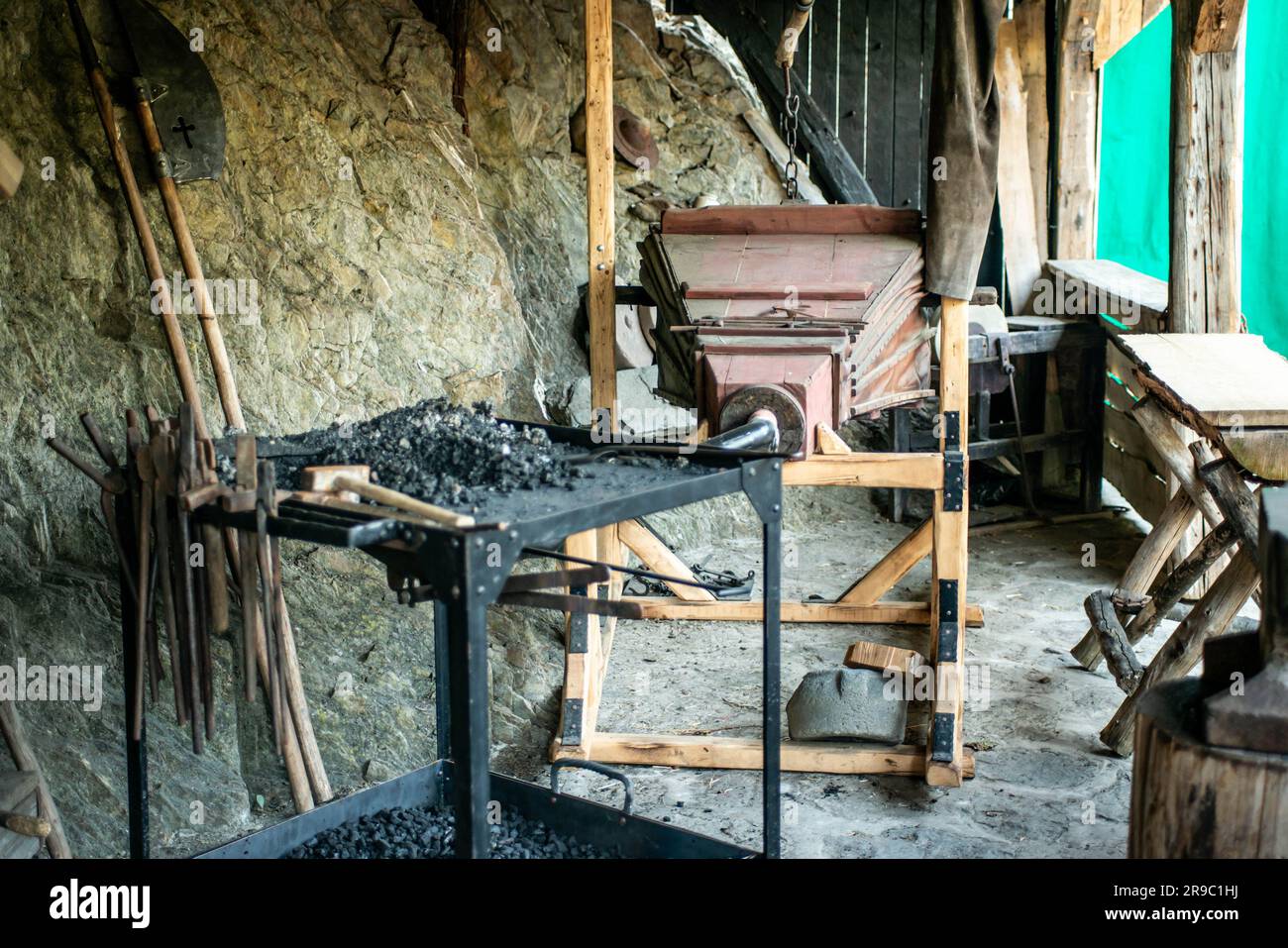 View of traditional blacksmith's shop for forging medieval iron, with furnace and an ancient bellows blower. Stock Photo