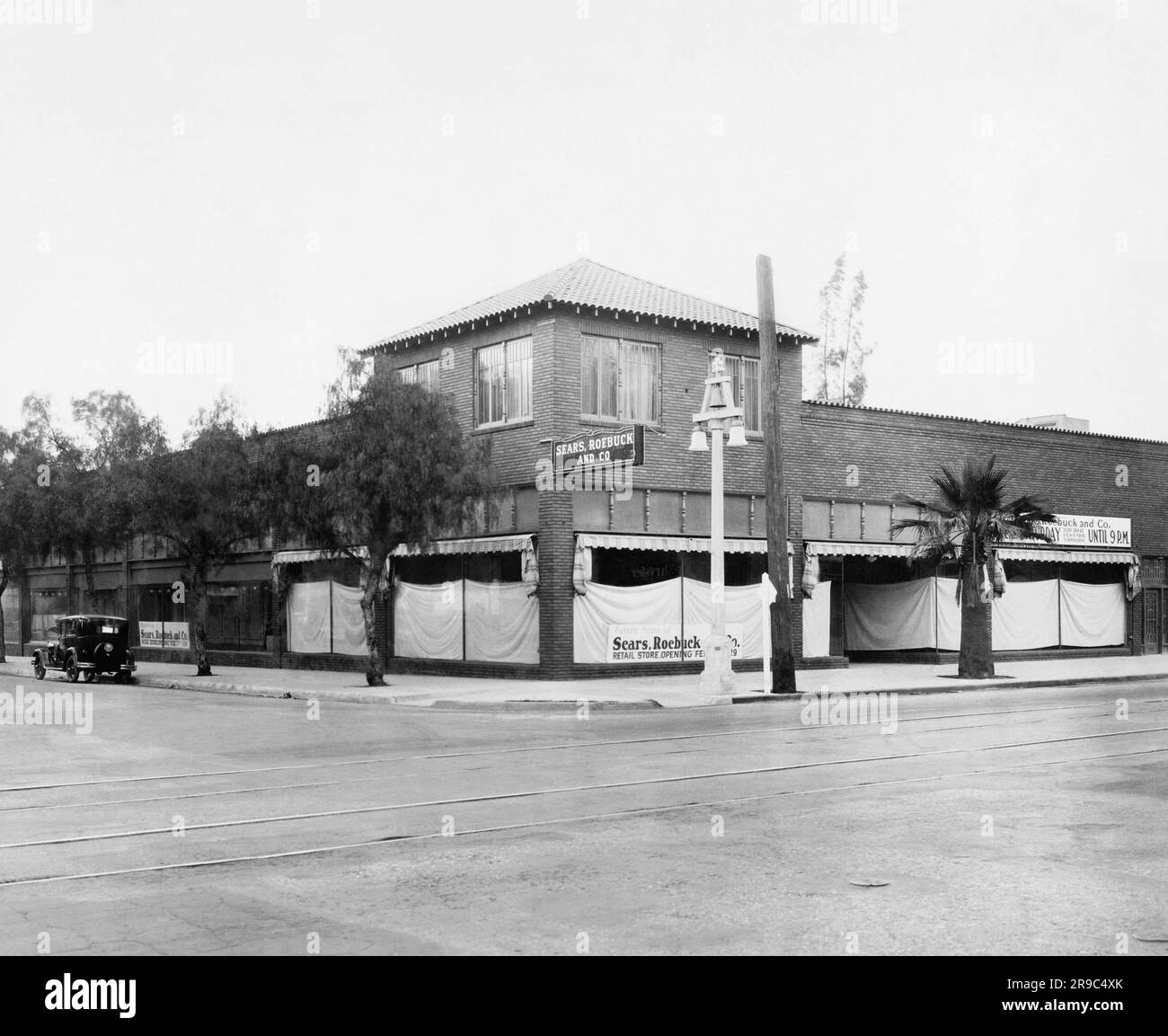 United States:  c. 1927 A corner location in a town where a Sears, Roebuck & Co. store will be opening soon. Stock Photo