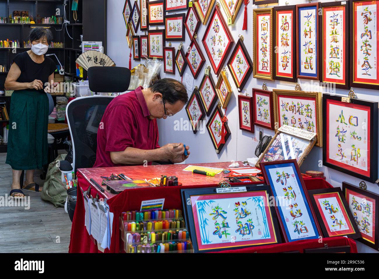 Sign writer and calligrapher working in shop at Stanley Market, Hong Kong, SAR, China Stock Photo