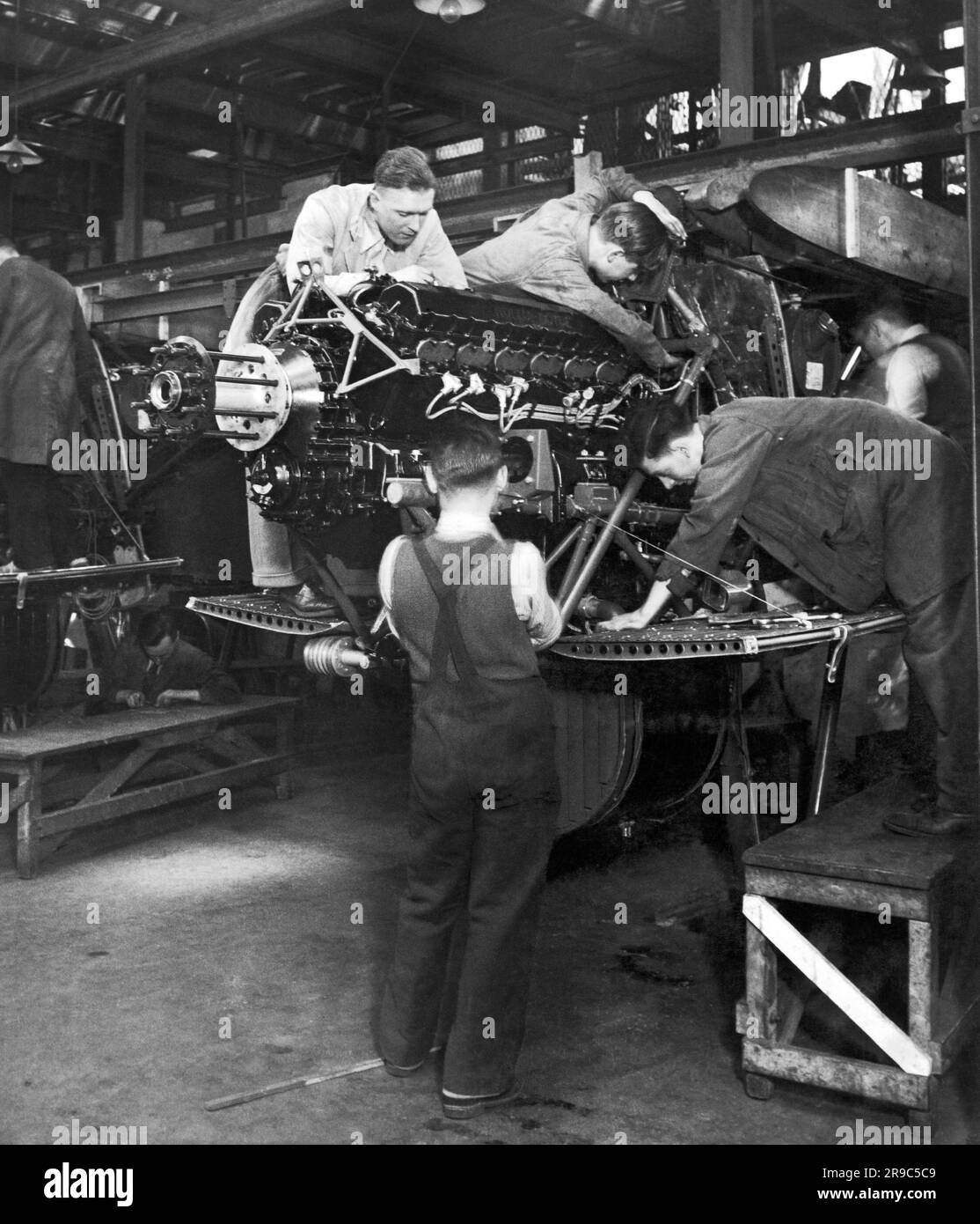 London, England:  c. 1936 Workers at Handley Page's Cricklewood works engaged in the government expansion mandate to triple the size of the Royal Air Force by March 31, 1937. Here the workers are assembling the engine mountings. Stock Photo