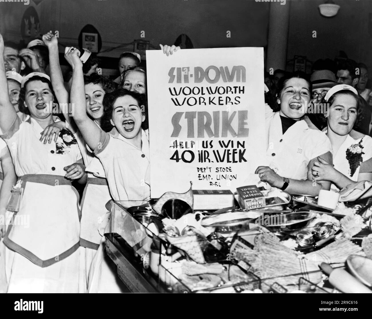 New York, New York: 1937  Female employees of Woolworth's holding a sign indicating they are striking for a 40 hour work week Stock Photo
