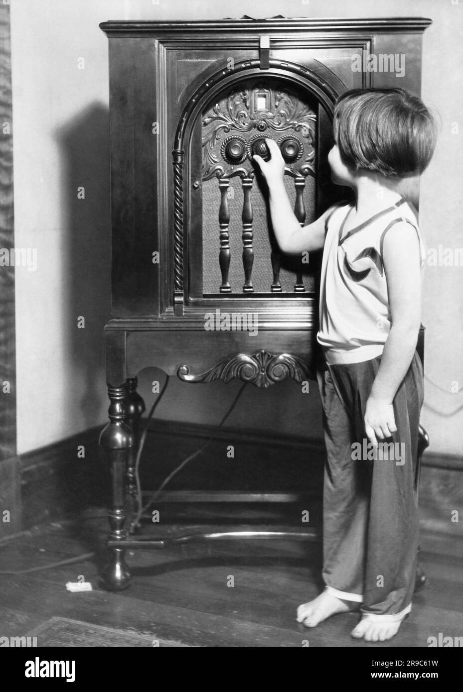 Norway, Maine:  c. 1929 A five year old girl tunes the radio into her station. Stock Photo