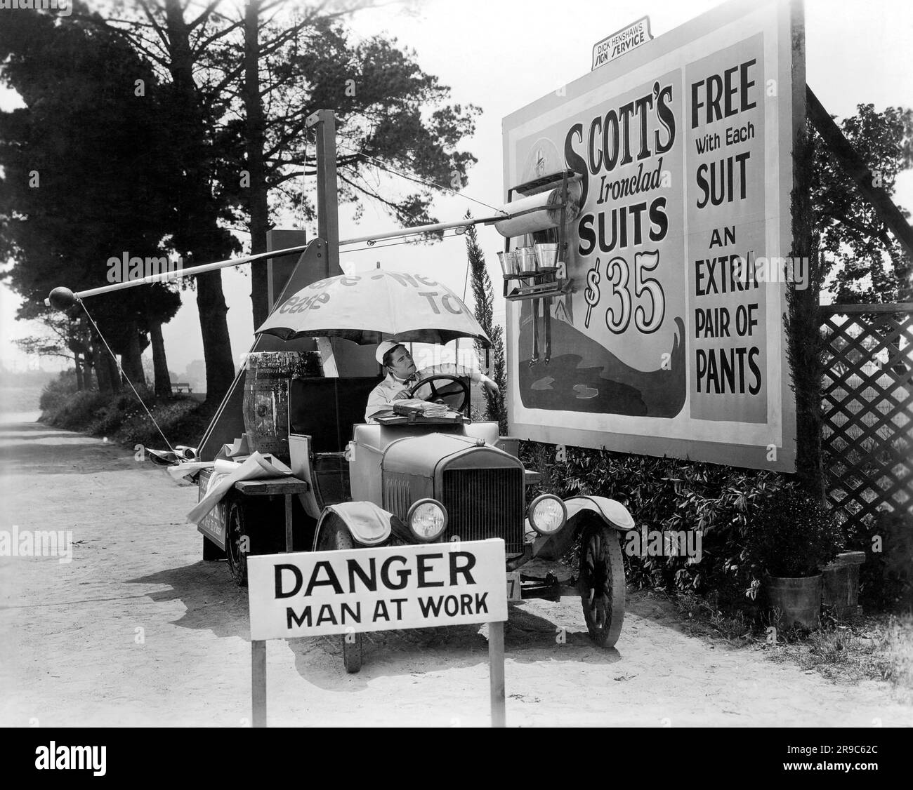 Hollywood, California:  1928 Actor Glenn Tryon demonstrates his labor saving automatic bill poster device in the movie, 'The Gate Crasher', directed by William Craft. Stock Photo
