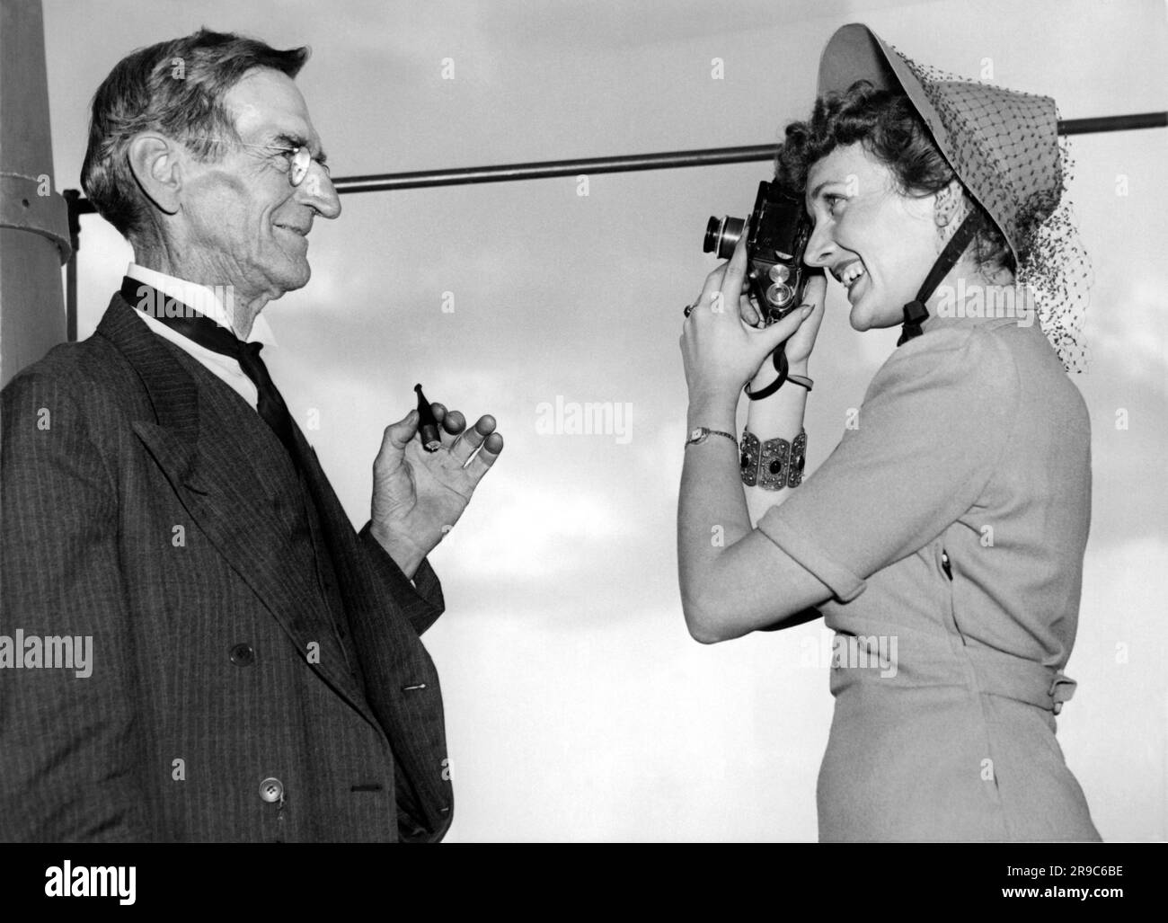 Washington D.C., 1938 A smiling woman takes a photograph of her father as he poses for the camera. Stock Photo