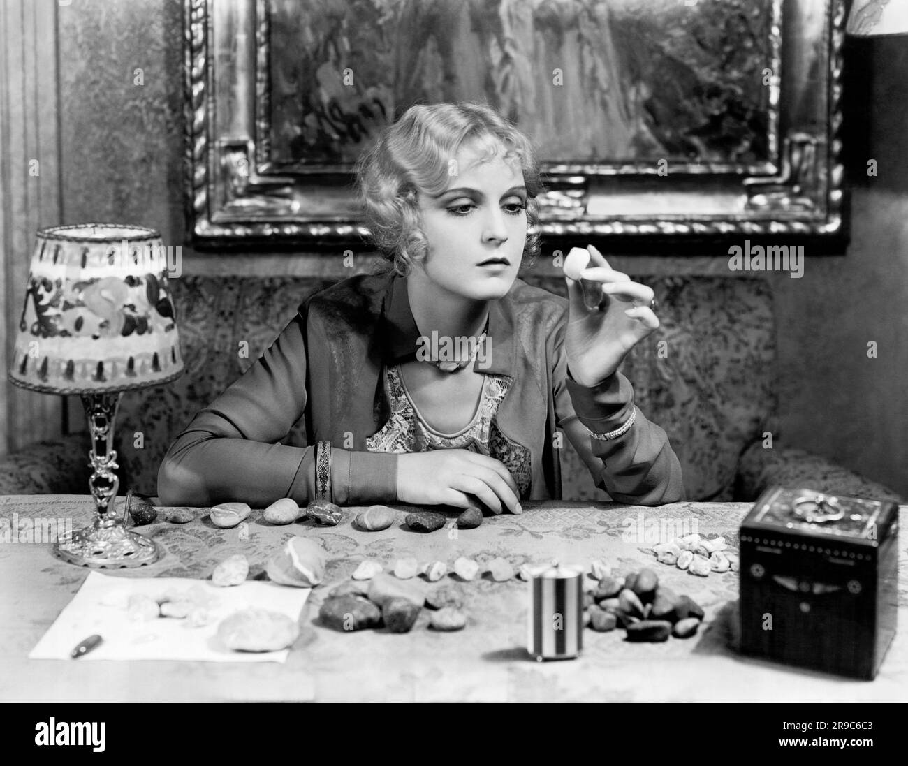 Los Angeles, California:  March 23, 1929 Hollywood movie star Camilla Horn examing some of the rare  moonstones she has collected during her walks on the beaches near her home. Stock Photo